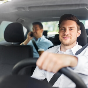Professional private driver in a suit providing executive transportation for a business traveler in Mexico.