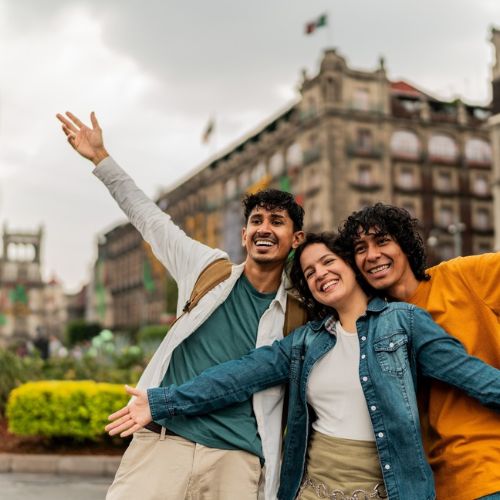 Friends smiling and exploring the historic downtown architecture of Mexico City on a guided walk.