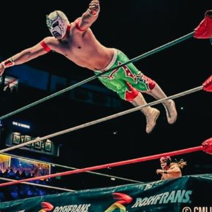 Luchador taking a dive from the ring to the audience