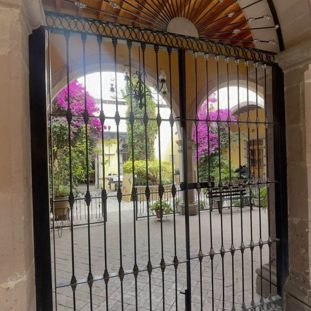 View of an arched colonial patio filled with bougainvilleas in Durango Mexico